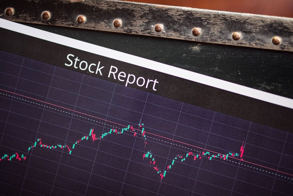 Close-up of a printed stock report showing a candlestick price chart on a dark grid background.